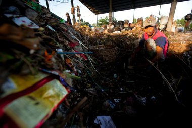 BALI, INDONESIA  APRIL 11: Poor from Java island working in a scavenging at the dump on April 11, 2012 on Bali, Indonesia. Bali daily produced 10,000 cubic meters of waste.